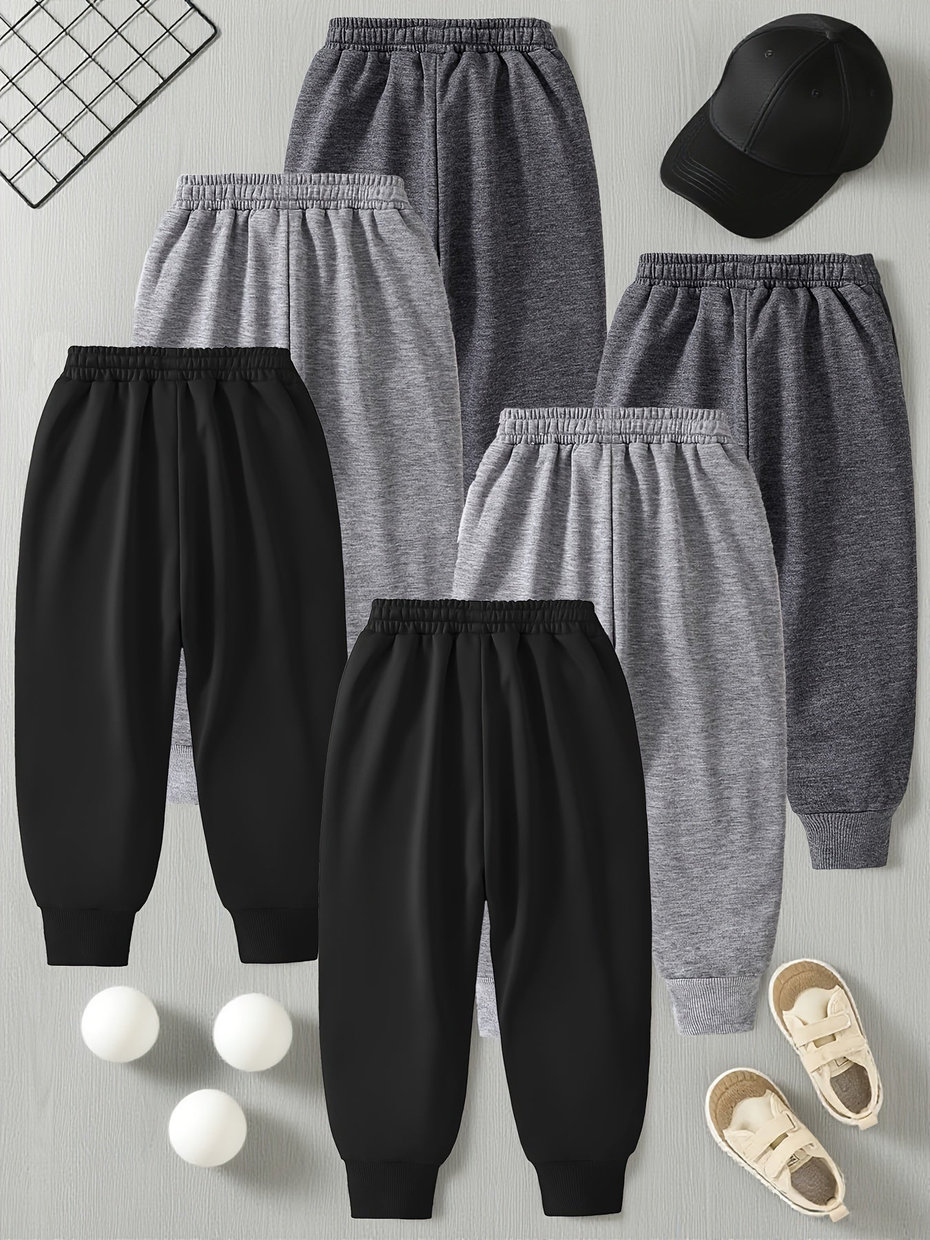 6 Pairs Of Children's Sportswear Pants, Mainly In Black And Gray Tones, with Different Trendy Words And Patterns Printed On The Pant Legs, Featuring An Overall Design Full Of Street Coolness, Suitable for Various Styles Of To