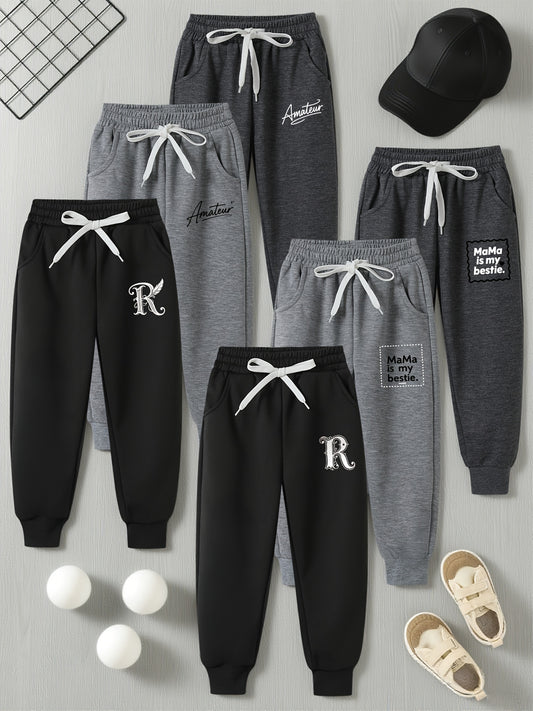 6 Pairs Of Children's Sportswear Pants, Mainly In Black And Gray Tones, with Different Trendy Words And Patterns Printed On The Pant Legs, Featuring An Overall Design Full Of Street Coolness, Suitable for Various Styles Of To